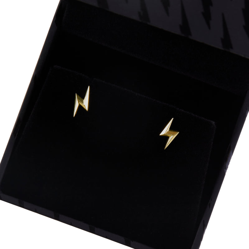 Close view of officially licensed Harry Potter Lightning Bolt Earrings in solid 14k yellow gold resting in a black earring box on a white background. Also available in sterling silver and 18k yellow gold.