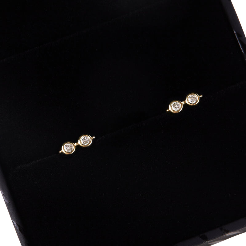 Close up view of officially licensed Harry Potter Glasses Stud Earrings in solid 14k gold set with natural diamonds in a black earring box on a white background. Also available in solid 18k yellow gold.