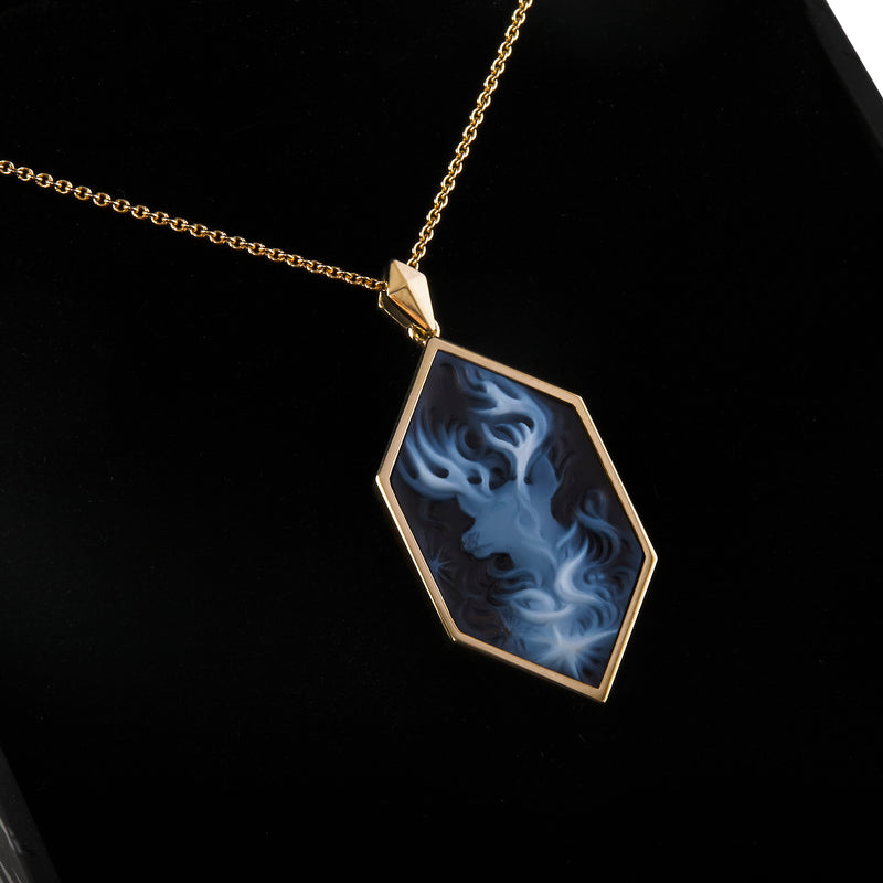 Close up view of officially licensed Harry Potter Patronus Cameo Necklace featuring a hand-carved agate set in solid 14k yellow gold in a black box on a white background. Also available in sterling silver, 14k white gold, 18k yellow gold, and platinum.