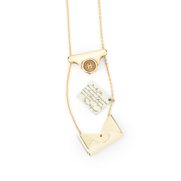 Officially licensed Harry Potter Hogwarts Acceptance Letter Necklace in solid 14k yellow gold on a white background. Envelope is opened to view the acceptance letter hidden inside. Also available in sterling silver, 14k white gold, 18k yellow gold, and platinum.